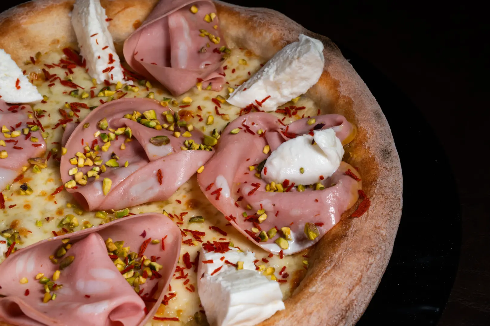 Gourmet pizza with prosciutto crudo at Bouganville restaurant in Trento